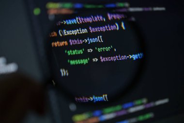 php kodunun, geliştirme ortamında karanlık ekran arkaplanındaki büyüteç altında json tepkisi ile ilgili hata işleme görüntülerini gösteren yakın plan