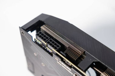 Modern bir GPU üzerinde çift 8-pin güç bağlantıları ve PCIe arayüzü, yüksek performanslı masaüstü grafik kartı için ayrıntılı soğutma yüzgeçleri ve bağlantı portlarını gösterir