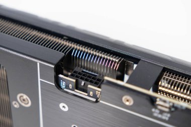 Modern grafik kartında görünen ısıtıcı yüzgeçleri ve siyah metal arka plakalı 8-pin güç bağlantısına yakın çekim