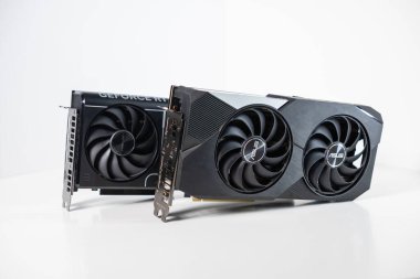Poznan, Polonya - 28 Mart 2025: Asus GeForce RTX 3070 ve 5070 grafik kartları beyaz arka planda çift ve üçlü fan tasarımı, portların yakın görüntüsü ve soğutma sistemi