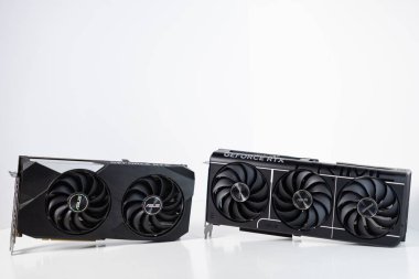 Poznan, Polonya - 28 Mart 2025: Asus GeForce RTX 3070 ve RTX 5070 grafik kartları yan yana, yüksek performanslı oyun bilgisayarı için çift ve üçlü fan modelleri beyaz arka plan üzerine inşa edilir
