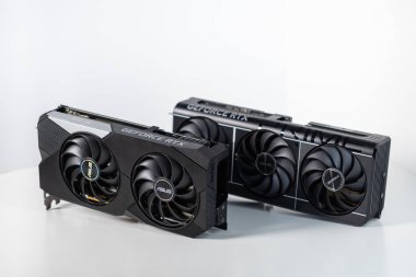 Poznan, Polonya - 28 Mart 2025: İki yeni Asus GeForce RTX 3070 ve RTX 5070 grafik kartları, çift vantilatör ve üçlü fan soğutma tasarımları, bilgisayar binası ve karşılaştırma için beyaz arka planda sergilendi