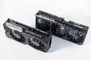 Poznan, Polonya - 28 Mart 2025: Çift ve üçlü fan soğutmalı iki yeni ASUS GeForce RTX grafik kartı, modern oyun bilgisayarı veya iş istasyonu inşaatı için beyaz arka planda sergileniyor