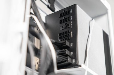 Bir PC kutusu içerisindeki modüler güç tedarik ünitesinin yakın plan görüntüsü, bilgisayar kurulumu sırasında bağlı olan PCIe, P8 ve DRIVES gibi etiketlenmiş portları gösterir.