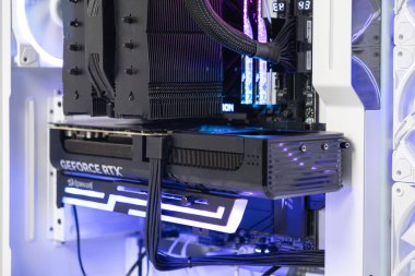 Poznan, Polonya - 30 Mart 2025: GeForce RTX grafik kartı güçlü soğutma ve kablo yönetimi içeren modern aydınlatma oyun bilgisayarının içinde özel destek parantezi ile bağlandı ve monte edildi