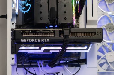 Poznan, Polonya - 30 Mart 2025: GeForce RTX GPU 'nun yakın çekimi bir oyun PC dosyasına monte edildi. Aydınlatılmış tutucu sarkmayı önler