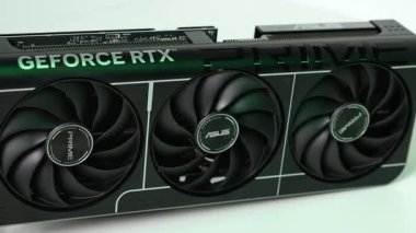 Poznan, Polonya - 27 Mart 2025: ASUS GeForce RTX 5070 PRIME grafik kartı yakın çekim üçlü yelpaze ve üst yüzeyinde yeşil ortam ışıklandırmasıyla zarif siyah kaplama