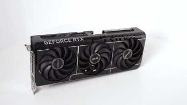 Poznan, Polonya - 27 Mart 2025: ASUS GeForce RTX 5070 PRIME grafik kartı ve üç büyük soğutma vantilatörü beyaz bir yüzey üzerinde dikey olarak sergilenmektedir. Temiz siyah desenli güçlü modern GPU