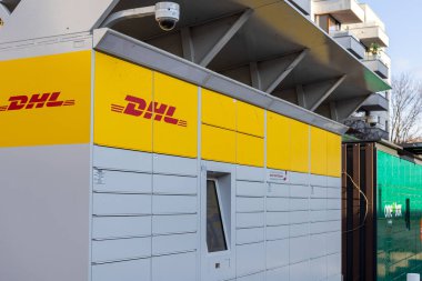 Poznan, Polonya - 15 Mart 2025: Sarı damgalı ve dokunmatik ekranlı DHL paket dolabı yerleşim yerlerinin yakınlarındaki paketleri toplamak veya göndermek için