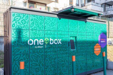 Poznan, Polonya - 15 Mart 2025: Allegro 'nun dokunmatik ekranlı ve renkli markalı One Box dolap ünitesi güneşli bir günde konut binalarının önünde duruyor.