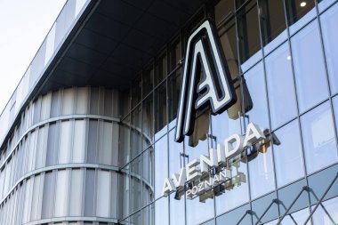 Poznan, Polonya - 15 Mart 2025: avenida Posnan alışveriş merkezi dışı modern cam cepheli ve büyük ölçekli şehir mimarisi perspektifi altında bir logoyu aydınlattı