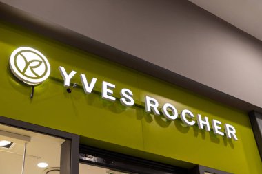 Poznan, Polonya - 15 Mart 2025: Yves Rocher, alışveriş merkezinin içindeki doğal kozmetik ve cilt ürünlerini modern perakende tasarımı ile tanıtan canlı yeşil duvar üzerindeki mağaza logosunu aydınlattı