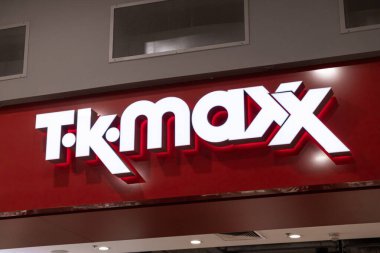 Poznan, Polonya - 15 Mart 2025: Parlak ışıklandırılmış TK Maxx mağaza logosu alışveriş merkezinin içindeki kırmızı duvarda popüler moda ve ev eşyaları perakendecisi girişini gösteriyor