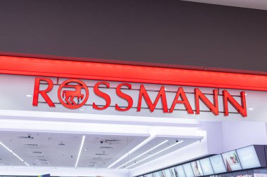 Poznan, Polonya - 15 Mart 2025: Rossmann mağaza girişi, alışveriş merkezinin içinde aydınlatılmış kırmızı logo ve modern iç aydınlatma, popüler eczane ve güzellik zinciri sergileniyor
