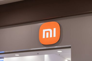 Poznan, Polonya - 15 Mart 2025: Xiaomi mağazası girişi, alışveriş merkezinin içindeki ışıklı duvarda tanınabilir turuncu mi logosu, minimalist markalaşma ve temiz iç tasarım sergileniyor