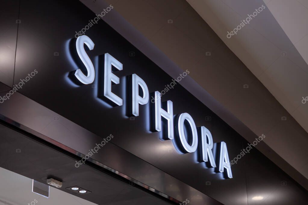 Poznan, Poland - March 15, 2025: Sephora store entrance with illuminated brand sign on sleek black wall inside shopping mall, featuring clean modern design and minimalistic lighting