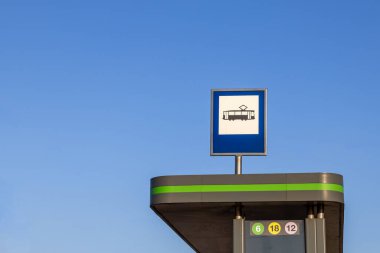 Modern barınağın tepesindeki tramvay durağı açık mavi gökyüzüne karşı açık mavi çizgili ve güneşli bir günde şehir toplu taşıma alanında hiç kimse yok.
