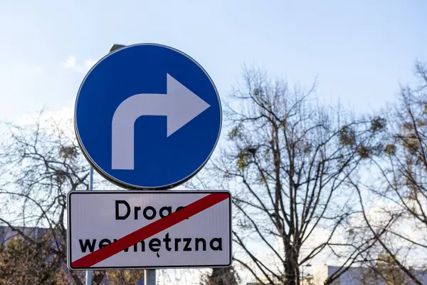 Şehir planına ve güpegündüz yapraksız ağaçlara karşı zorunlu sağ dönüş ve iç yol uyarısı içeren trafik işareti