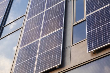 Modern bina cephesine kurulmuş güneş panelleri açık havada cam pencerelere yansıyan güneş ışığını yansıtıyor