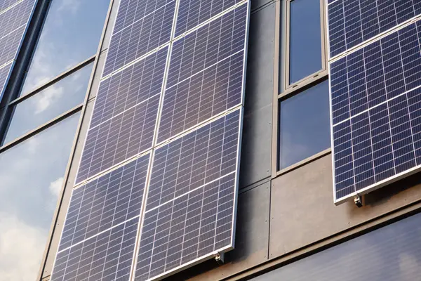 Modern bina cephesine kurulmuş güneş panelleri açık havada cam pencerelere yansıyan güneş ışığını yansıtıyor