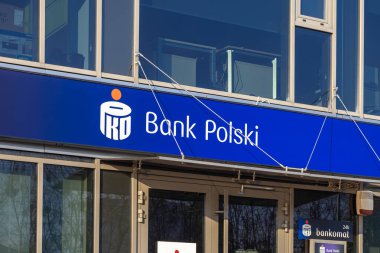 Poznan, Polonya - 22 Mart 2025: Polonya 'daki güneşli gün finans kurumunun yakın çekim görüntüsü sırasında cam bina cephesi üzerinde mavi işaret ve logoyla modern PKO Bank Polski dış görünüşü