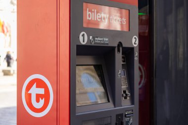 Varşova, Polonya - 3 Nisan 2025: Toplu taşıma için modern kırmızı bilet otomatı. Makine dokunmatik ekran görüntüsü, kart ödemesi ve nakit giriş seçenekleri sunar