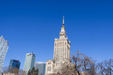 Varşova, Polonya - 3 Nisan 2025: Modern ofis gökdelenleri ile Kültür ve Bilim Sarayı manzarası. Şehrin klasik ve çağdaş mimariye zıt bir sembolü.