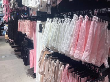 Poznan, Polonya - Nisan 02, 2025: Beyaz, pembe ve bej gibi yumuşak pastel renkte kadınların pijama şortlarının yakın çekim görüntüsü, dantelli detaylar, bir moda mağazasının uyku giysisi bölümünde asılı.. 