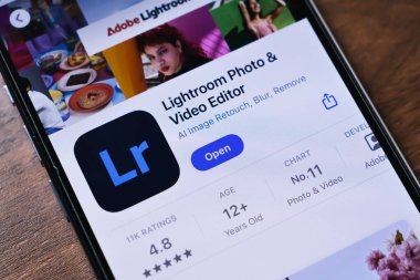 Poznan, Polonya - 26 Mart 2025: App Store 'daki Adobe Lightroom uygulamasını gösteren telefon ekranı, filtreli, ayarlı, yapay zeka araçlarıyla fotoğraf ve videoları geliştiren profesyonel bir editör