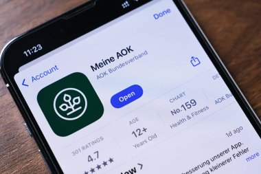 Poznan, Polonya - 26 Mart 2025: Meine AOK mobil uygulamasını Uygulama Mağazasında gösteren akıllı telefonun yakın çekimi, kullanıcı derecesi, yaş kısıtlaması ve sağlık kategorisini gösteriyor