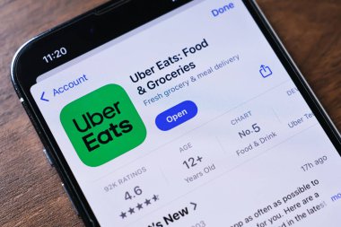 Poznan, Polonya - 26 Mart 2025: Uber Eats uygulamasını gösteren, yerel restoranları gezmek, yemek siparişi vermek ve hızlı teslimat yapan Uber Eats uygulamasını gösteren bir akıllı telefonun yakın çekimi