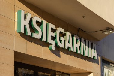 Poznan, Polonya - 8 Nisan 2025: Polonya 'daki bir kitapçının yakın görüntüsü, bej kaplama bir duvara asılmış büyük yeşil ve beyaz bir Ksiegarnia tabelasının yer aldığı