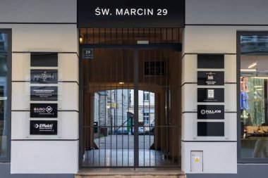 Poznan, Polonya - 8 Nisan 2025: Swiety Marcin 29 'daki çağdaş bir iş binasına giriş kapısı, aydınlatılmış şirket tabelaları ve yasal, saç, iş için dizin tahtaları