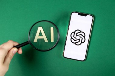 Poznan, Polonya 14 Nisan 2025: Akıllı telefonun yanında ChatGPT logosu gösteren, arama ve mobil yapay zeka araçlarına odaklanmayı temsil eden yapay zeka harflerinin yakınlaştırılması 