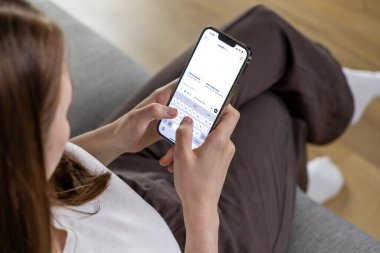 Poznan, Polonya 14 Nisan 2025: Bir kadın telefonunda ChatGPT uygulamasını kullanarak mobil bir metin arayüzü üzerinden yapay zeka ile iletişim kurmak için mesaj yazıyor. 