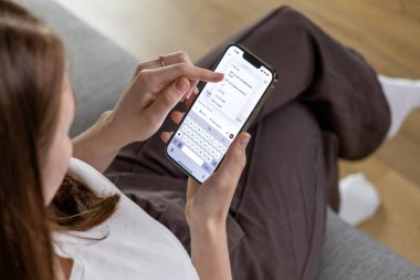 Poznan, Polonya 14 Nisan 2025: Bir kadın akıllı telefon tutuyor ve ChatGPT uygulamasından GPT modeli bir versiyonunu seçiyor, yapay zeka teknolojisiyle etkileşime geçiyor 