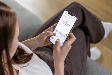Poznan, Polonya 14 Nisan 2025: Akıllı telefon tutan ve Claude Al uygulamasını kullanan bir kadın, bir sohbet arayüzü kullanarak yapay zeka ile iletişim kuruyor. 