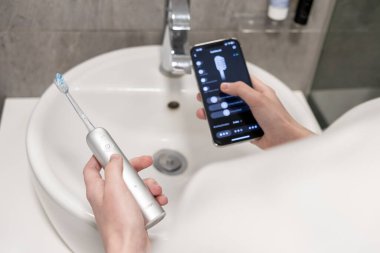 Poznan, Polonya - 27 Nisan 2025: Laifen Wave Elektrikli Diş fırçası ve akıllı telefon kontrol uygulaması modern kişiselleştirilmiş hijyen ve teknoloji entegrasyonunu temsil ediyor