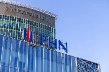 Poznan, Polonya - 30 Nisan 2025: Polski Holding Nieruchomosci (PHN) binasının dış görünüşü, modern mimari, cam paneller ve temiz gökyüzüne karşı tanınmış PHN logosu