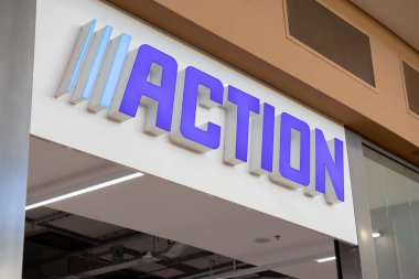 Poznan, Polonya - 30 Nisan 2025: Girişin üstündeki binanın dış tarafındaki belirgin mavi-beyaz Action markası müşteriler için perakende indirim mağazasının varlığını gösteriyor