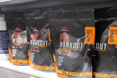 Poznan, Polonya - 30 Nisan 2025: Çeşitli siyah ve turuncu XXXL Beslenme Turuncu Lezzet Öncesi Egzersiz Ek Kese Perakende rafında sunulan spor besinlerinin ulaşılabilirliğini gösteren