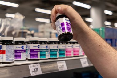 Poznan, Polonya - 30 Nisan 2025: Bir mağazadan Innovit Tüylü Tırnakları 'nı seçen bir elin yakın çekimi, kişisel bakım için hedeflenmiş vitaminler yoluyla günlük güzellik beslenmesini teşvik