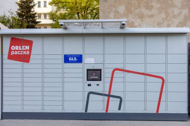 Poznan, Polonya - 25 Nisan 2025: ORLEN Paczka ve GLS markalı modern bir otomatik paket terminalinin dış görünümü paket alma ve boşaltma için otomatik self servis noktaları sağlıyor