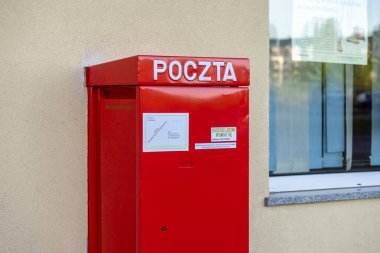 Poznan, Polonya - 25 Nisan 2025: Poczta Polska 'nın duvara monte edilmiş kırmızı posta kutusu geleneksel iletişim için gerekli mektup ve postaları depolamak için kamu erişimi sağlıyor
