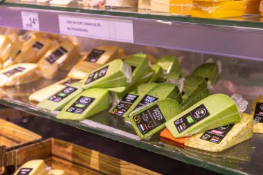 Poznan, Polonya - 25 Nisan 2025: Yeşil Pesto ve Gouda 'nın da aralarında bulunduğu çeşitli peynir tipleri bir perakende markette dondurulmuş bölümde satışa sunuldu