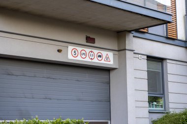 Garaj kapısının üstündeki yatay düzenleme paneli yüksekliği 5 metre genişliği 2 metre LPG kamyon kısıtlamaları ve uyarıda bulunan sürücüleri gösteriyor.