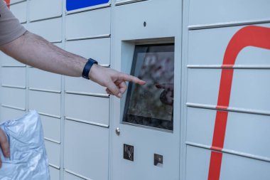 Yakın plan, otomatik parsel dolabında, e-ticaret dağıtımı için modern self-servis teknolojisini gösteren müşteri el dokunmatik ekranı arayüzünü gösteriyor.