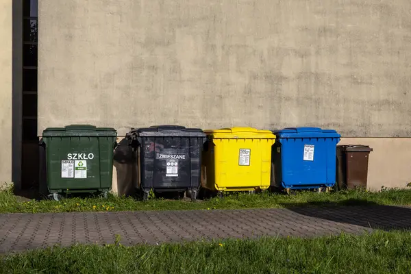 Poznan, Polonya - 25 Nisan 2025: Polonya 'daki Cam Karışık Kağıt metni atık ayıklama için renkli çöp kutuları kentsel geri dönüşüm çevre sorumluluğunu teşvik ediyor