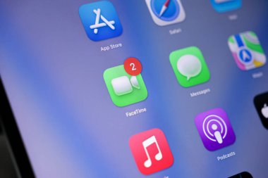 Poznan, Polonya - 15 Mayıs 2025: FaceTime uygulama simgesi, gerçek zamanlı iletişim ve video arama işlevselliği için diğer uygulama simgeleriyle birlikte dijital tablet ekranında iki uyarı göstermektedir