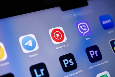Poznan, Polonya - 15 Mayıs 2025: YouTube Müzik ikonu, ekran merkezine yerleştirilmiş, şarkıları dinlemek, sanatçıları keşfetmek ve çevrimiçi müzik içeriğinden keyif almak için kullanılan koyu kırmızı oyun sembolü
